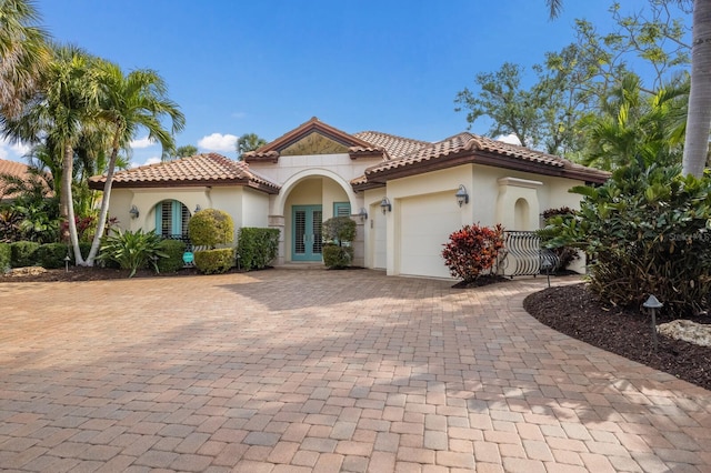 4946 Brywill Cir, Sarasota, FL 34234 - mediterranean / spanish house with french doors, an attached garage, decorative driveway, and stucco siding