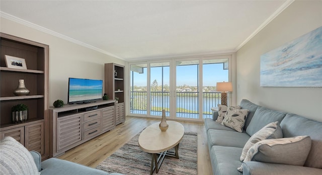 living room with light hardwood / wood-style flooring, ornamental molding, and a wall of windows