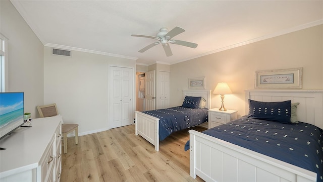 bedroom with multiple closets, ceiling fan, crown molding, and light hardwood / wood-style floors