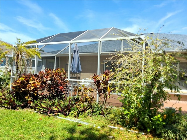 5115 44th St W, Bradenton, FL 34210 - view of home's exterior with a lanai, roof with shingles, and stucco siding