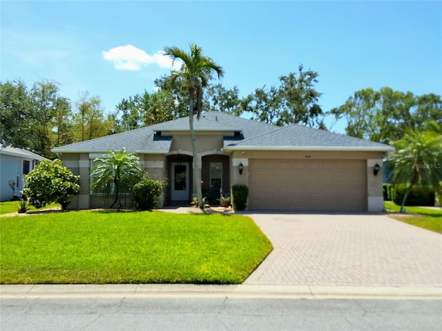 5115 44th St W, Bradenton, FL 34210 - single story home with roof with shingles, an attached garage, a front yard, stucco siding, and decorative driveway