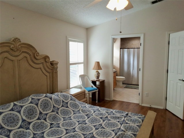 5115 44th St W, Bradenton, FL 34210 - bedroom featuring ensuite bathroom, a textured ceiling, visible vents, lofted ceiling, and wood finished floors