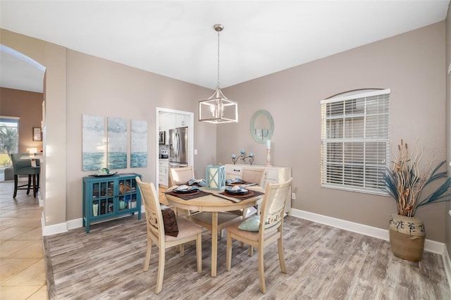 tiled dining room featuring a chandelier