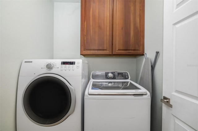 washroom featuring washer and clothes dryer and cabinets