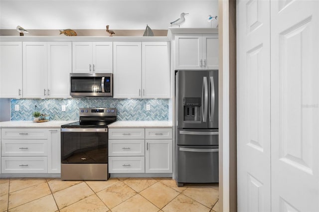 kitchen with white cabinetry, light tile patterned flooring, and appliances with stainless steel finishes