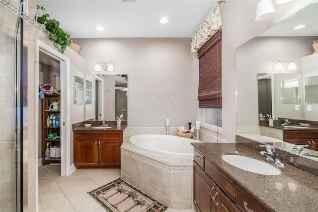 bathroom with tile patterned flooring, vanity, and separate shower and tub