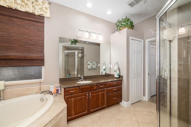 bathroom with shower with separate bathtub, vanity, and tile patterned floors