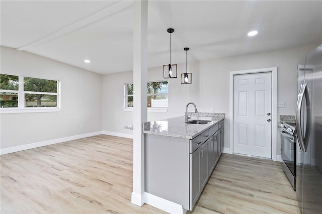 kitchen with light stone countertops, sink, stainless steel appliances, decorative light fixtures, and gray cabinets