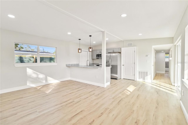 unfurnished living room with plenty of natural light and light hardwood / wood-style floors