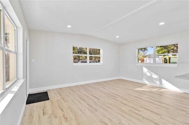 unfurnished room with lofted ceiling and light hardwood / wood-style flooring