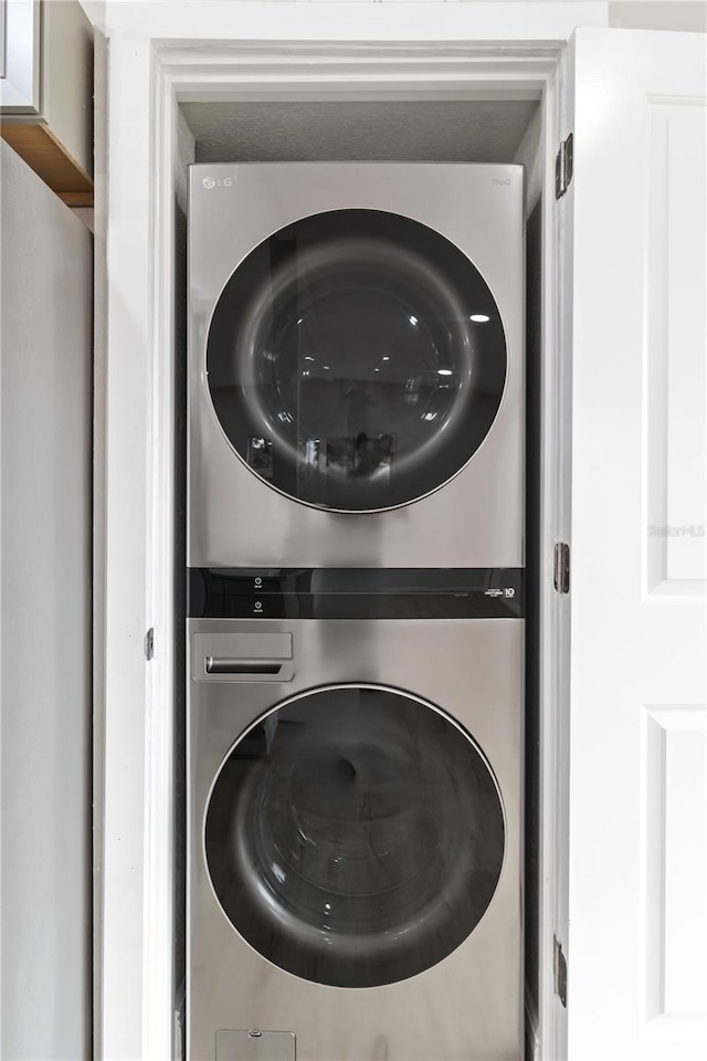 clothes washing area with stacked washer and clothes dryer