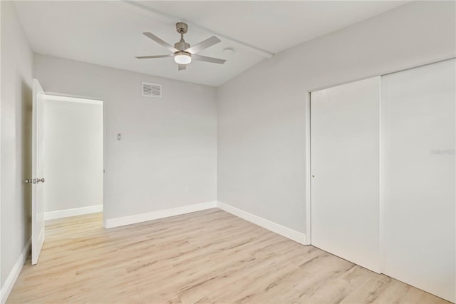 unfurnished bedroom with light wood-type flooring, a closet, and ceiling fan