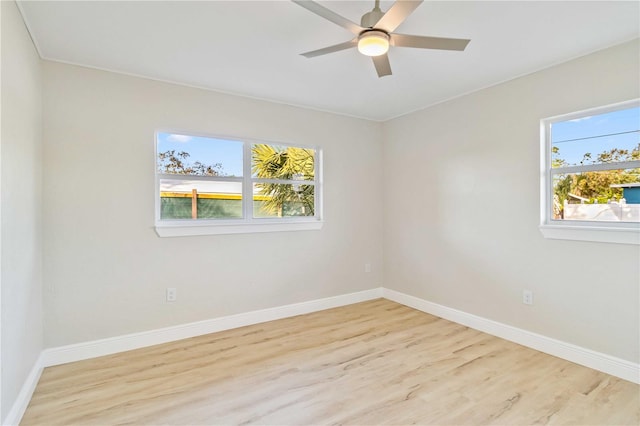 empty room with ceiling fan, plenty of natural light, and light hardwood / wood-style floors