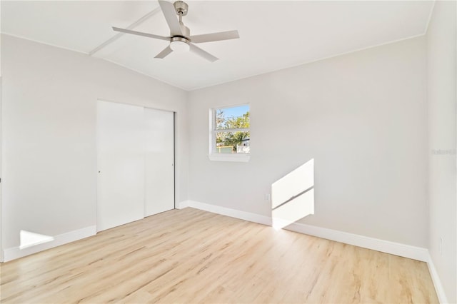 spare room featuring ceiling fan, light hardwood / wood-style floors, and lofted ceiling