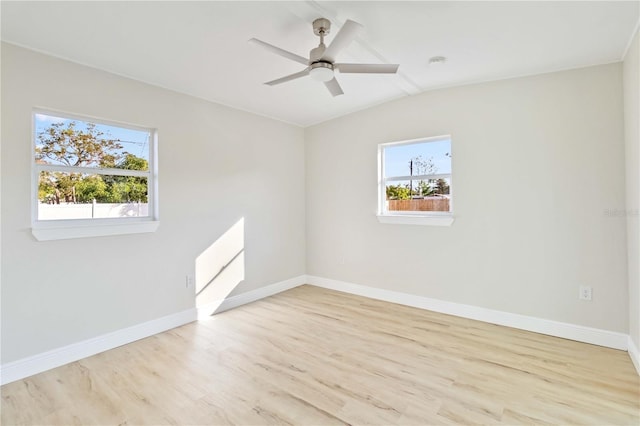 spare room featuring ceiling fan, vaulted ceiling, and light wood-type flooring