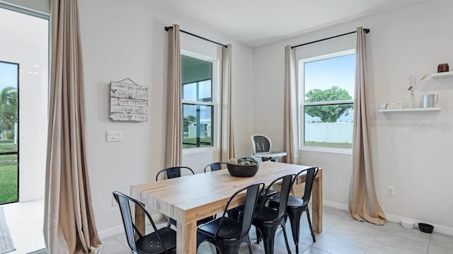 tiled dining space featuring a healthy amount of sunlight