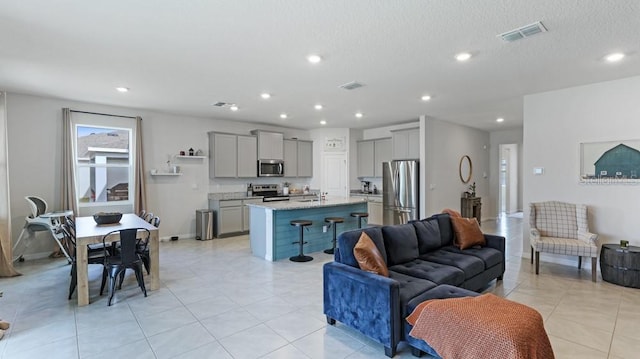 tiled living room with sink and a textured ceiling