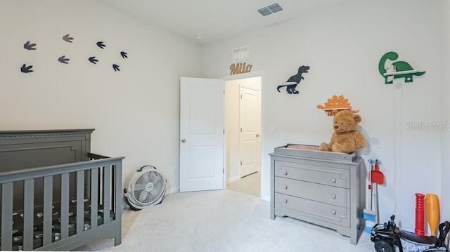 bedroom with a crib and light carpet