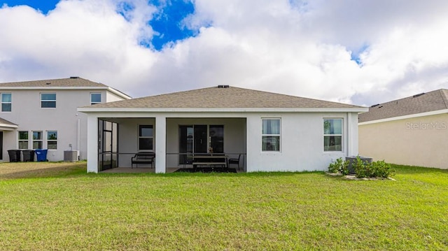 rear view of property with a lawn, a sunroom, and central air condition unit