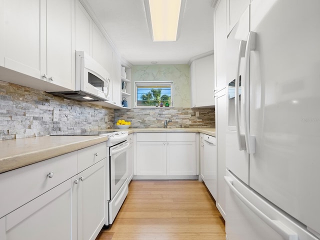 kitchen with decorative backsplash, white appliances, light hardwood / wood-style flooring, and white cabinetry