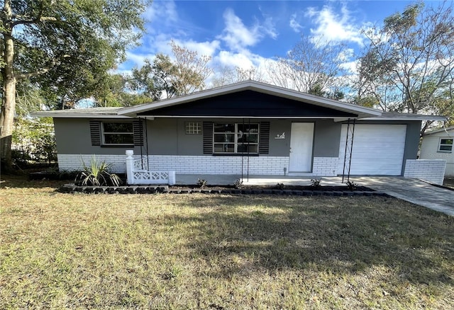 single story home featuring a front lawn, covered porch, and a garage