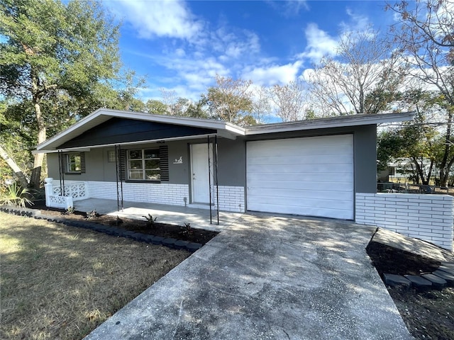 ranch-style house featuring covered porch and a garage