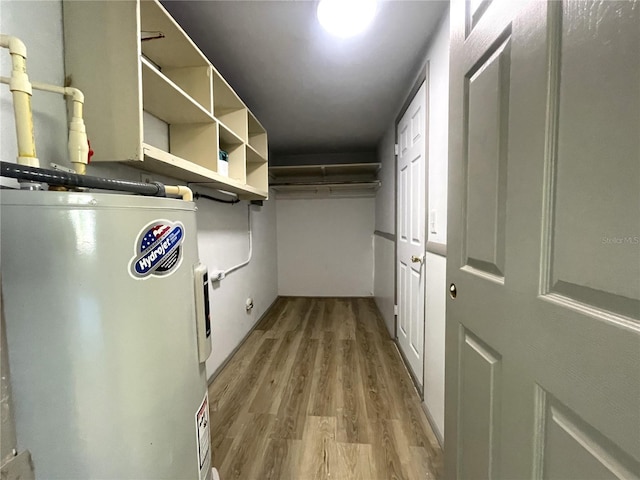 spacious closet featuring light wood-type flooring and water heater