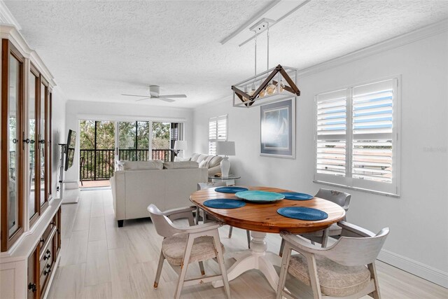 dining room featuring ceiling fan, ornamental molding, and a textured ceiling