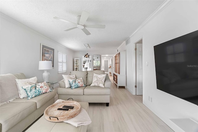 living room with ornamental molding, ceiling fan, and a textured ceiling