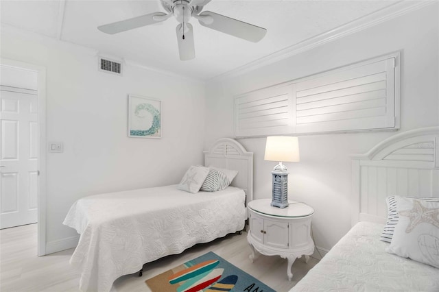 bedroom with ornamental molding, ceiling fan, and light hardwood / wood-style flooring