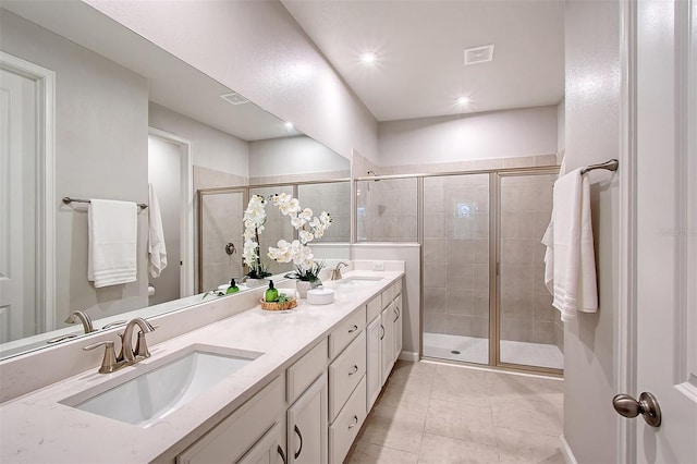 bathroom featuring tile patterned flooring, vanity, and a shower with door