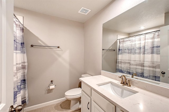 bathroom with a textured ceiling, vanity, and toilet