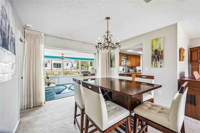 dining area featuring a textured ceiling, ceiling fan with notable chandelier, and light carpet