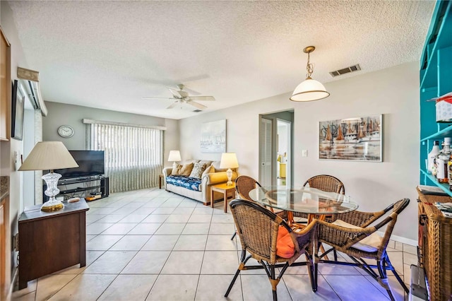 tiled dining area featuring ceiling fan and a textured ceiling