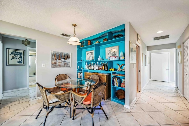 dining room with light tile patterned floors and a textured ceiling