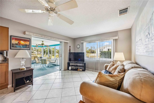 tiled living room featuring a textured ceiling and ceiling fan