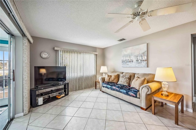 tiled living room featuring ceiling fan and a textured ceiling