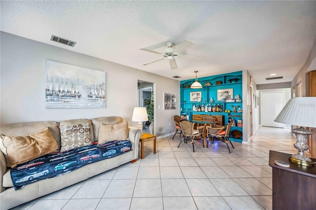 tiled living room with ceiling fan and a textured ceiling