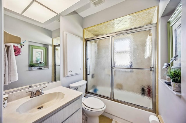 full bathroom featuring vanity, bath / shower combo with glass door, and toilet