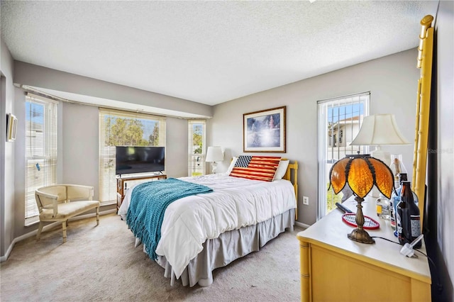 carpeted bedroom with a textured ceiling and multiple windows