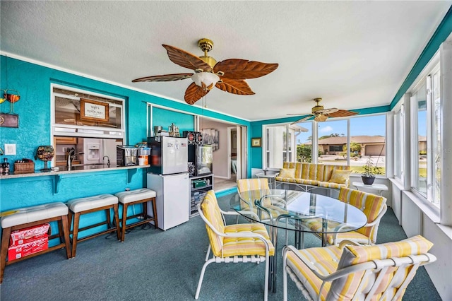 dining space featuring dark colored carpet, crown molding, and a textured ceiling