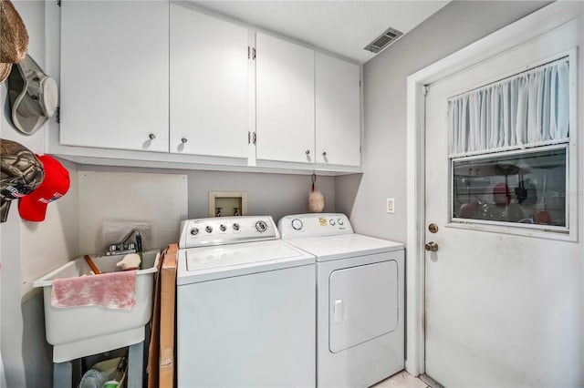 laundry room featuring washer and clothes dryer, cabinets, and sink