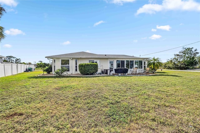 rear view of property with a patio area and a lawn