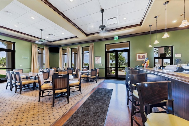 dining room featuring crown molding, a tray ceiling, french doors, and hardwood / wood-style flooring