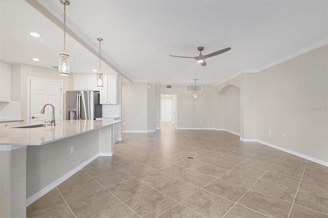 kitchen featuring stainless steel refrigerator with ice dispenser, sink, pendant lighting, ceiling fan, and white cabinets