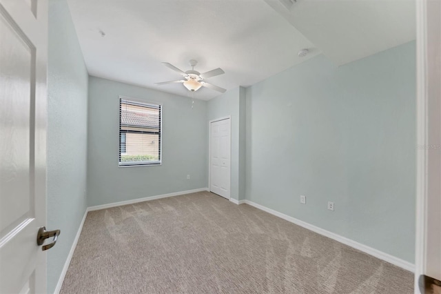 empty room featuring light carpet and ceiling fan