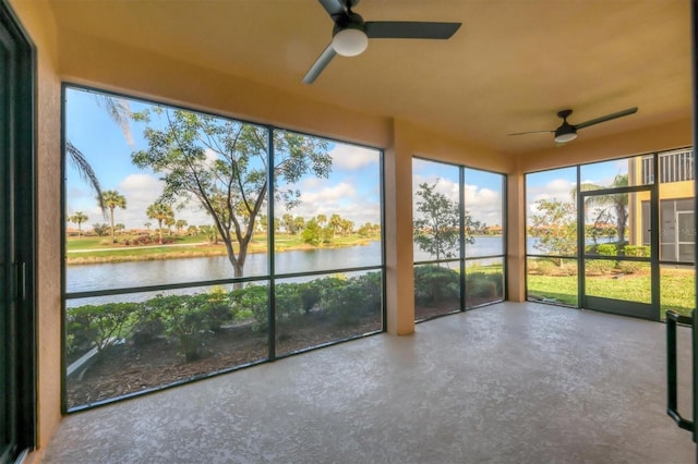 unfurnished sunroom with a water view and ceiling fan