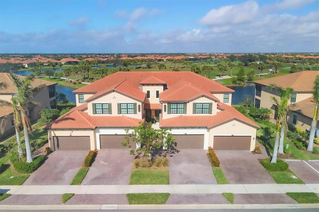 mediterranean / spanish home with a garage and a water view