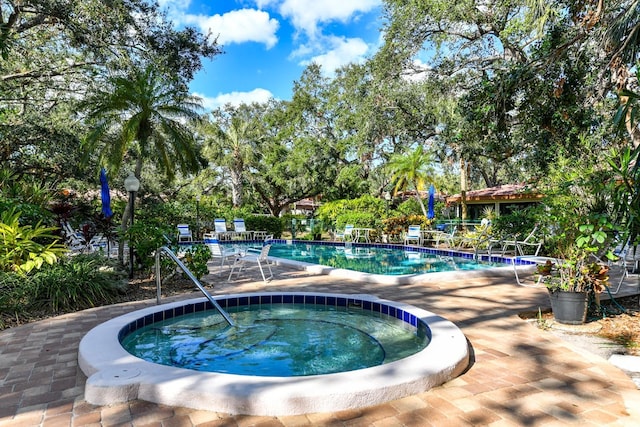 view of swimming pool featuring an in ground hot tub