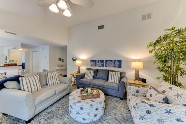 living room featuring ceiling fan and a towering ceiling